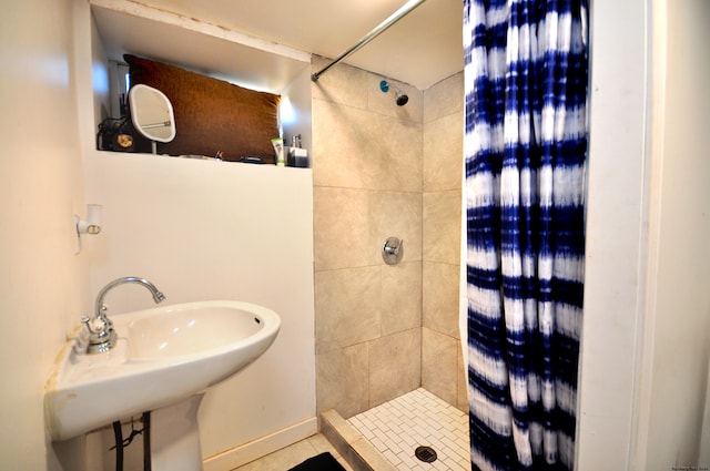 bathroom featuring tile patterned floors, sink, and tiled shower