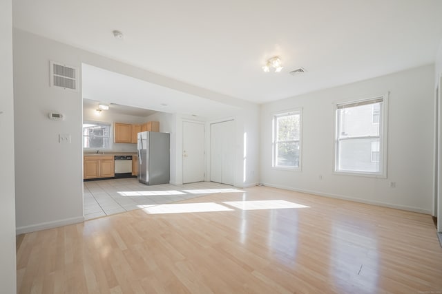 unfurnished living room featuring light hardwood / wood-style flooring and sink