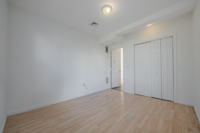 unfurnished bedroom with a closet and light hardwood / wood-style flooring