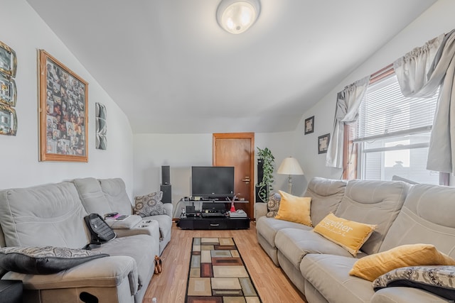 living room with light hardwood / wood-style floors and vaulted ceiling