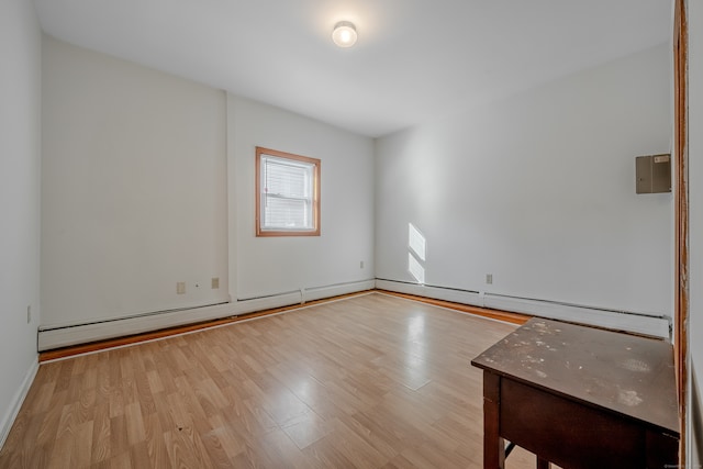 unfurnished room with a baseboard radiator and light hardwood / wood-style flooring