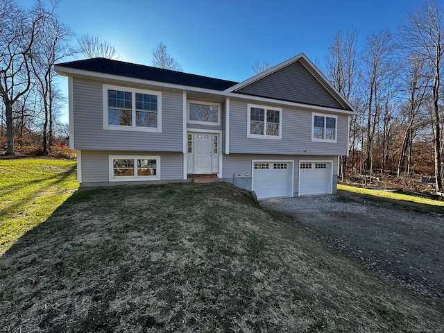 raised ranch featuring a front yard and a garage