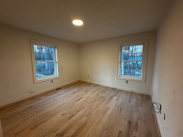 unfurnished room with plenty of natural light and light hardwood / wood-style flooring