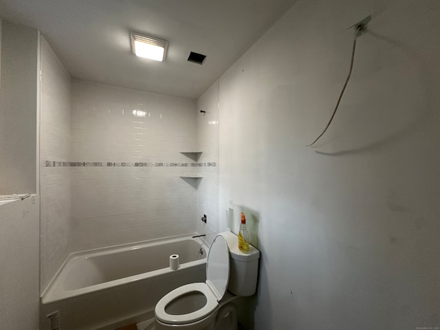 bathroom with tiled shower / bath combo and toilet