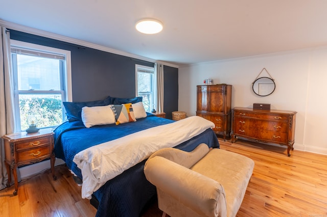 bedroom featuring light hardwood / wood-style floors and crown molding