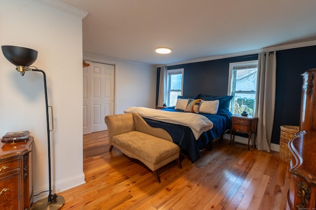 bedroom featuring light wood-type flooring and crown molding