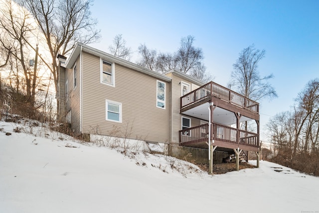 snow covered property featuring a wooden deck