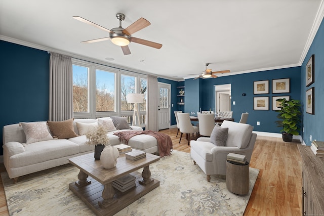 living room with ceiling fan, ornamental molding, and light hardwood / wood-style floors