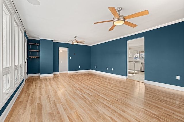 spare room featuring baseboard heating, light hardwood / wood-style flooring, and crown molding