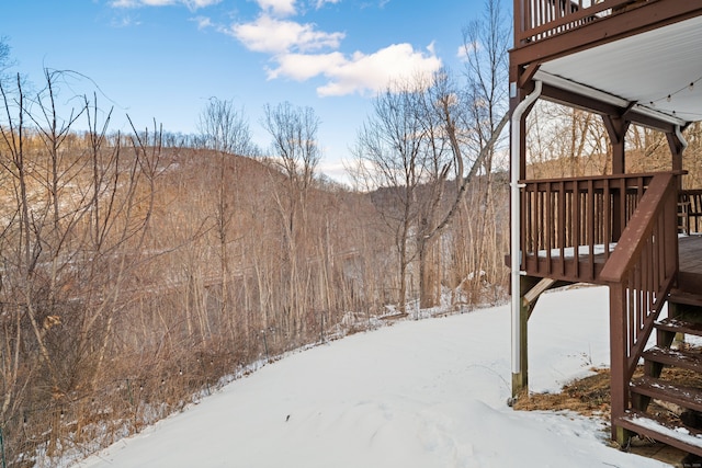 yard layered in snow with a wooden deck