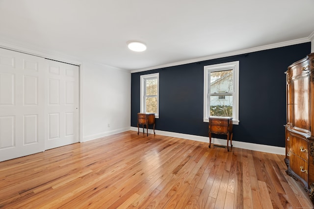 unfurnished bedroom with light wood-type flooring, a closet, and ornamental molding