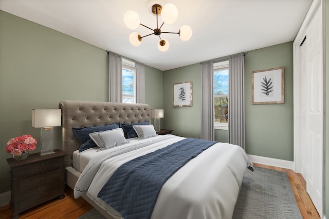 bedroom featuring an inviting chandelier and wood-type flooring