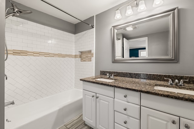 bathroom with tiled shower / bath combo and vanity