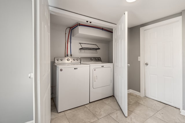 laundry room with light tile patterned floors and washer and clothes dryer