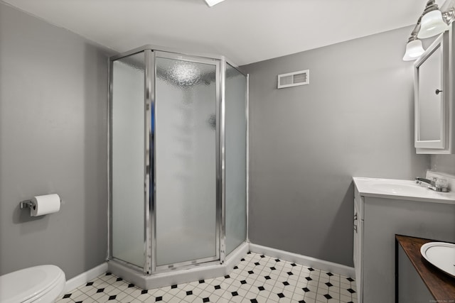 bathroom featuring toilet, an enclosed shower, and vanity