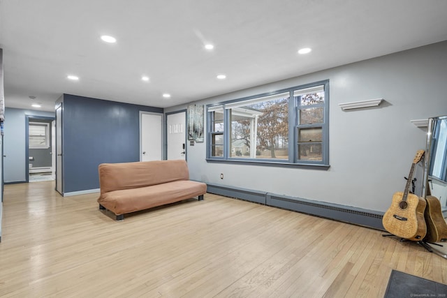 sitting room with a baseboard heating unit and light hardwood / wood-style flooring