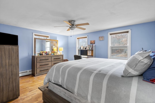 bedroom with a baseboard radiator, ceiling fan, and light wood-type flooring