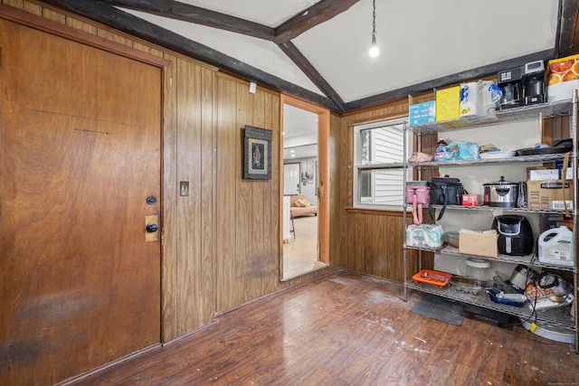 entryway with hardwood / wood-style floors, wooden walls, and lofted ceiling with beams