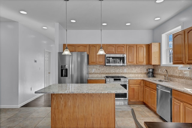 kitchen featuring stainless steel appliances, a kitchen island, hanging light fixtures, and sink