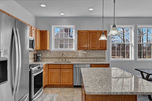 kitchen with a wealth of natural light, sink, a center island, and stainless steel appliances