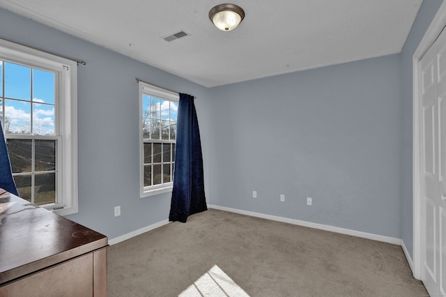 interior space featuring light carpet and multiple windows