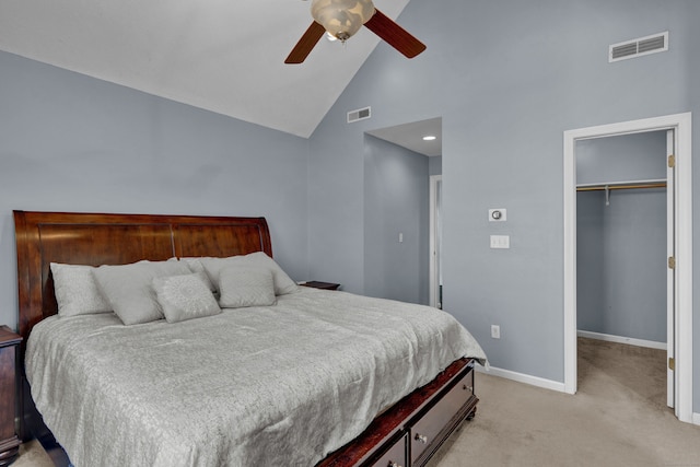 bedroom featuring light carpet, ceiling fan, a spacious closet, high vaulted ceiling, and a closet