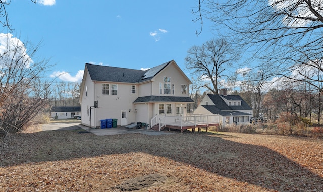 rear view of property featuring a lawn and a wooden deck