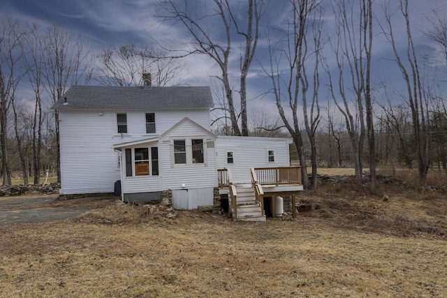 rear view of property featuring a wooden deck