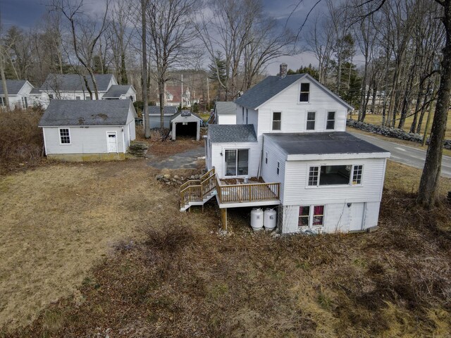 rear view of property featuring an outdoor structure and a wooden deck