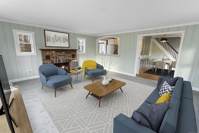 living room with crown molding, a fireplace, and carpet