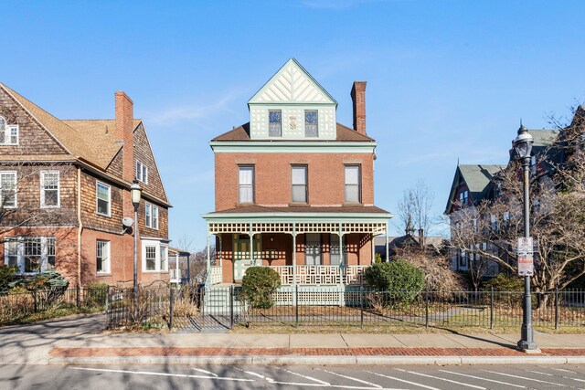 view of front of house featuring uncovered parking, covered porch, a fenced front yard, and a chimney