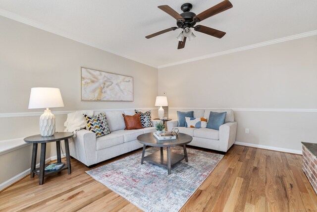 living room featuring baseboards, wood finished floors, a ceiling fan, and crown molding