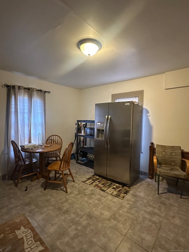 dining space featuring a wall unit AC and tile patterned flooring