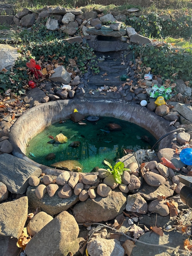 exterior details with a garden pond