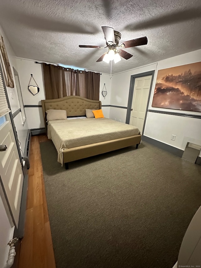 bedroom with ceiling fan, dark wood-type flooring, and a textured ceiling