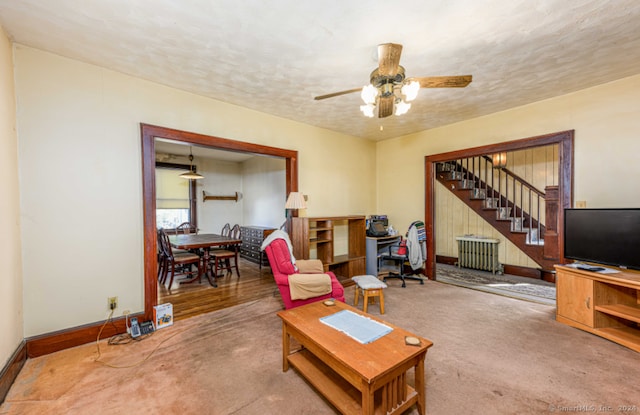 living room with carpet flooring, ceiling fan, a textured ceiling, and radiator