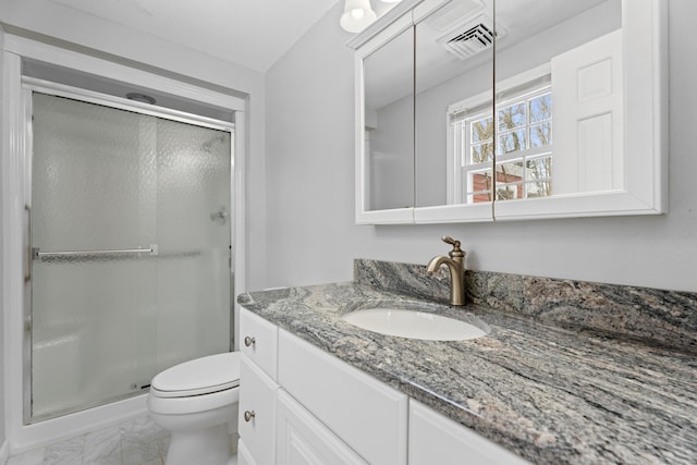 bathroom featuring a shower with door, vanity, and toilet