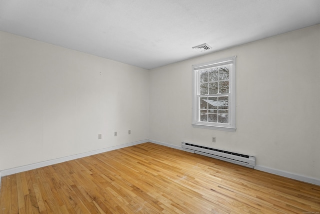 empty room featuring light hardwood / wood-style flooring and baseboard heating