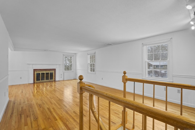 living room with light hardwood / wood-style floors and a brick fireplace