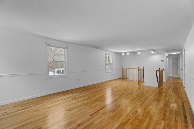 unfurnished room with rail lighting, light hardwood / wood-style flooring, and plenty of natural light