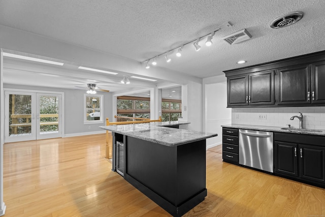 kitchen with dishwasher, a center island, light hardwood / wood-style floors, and sink