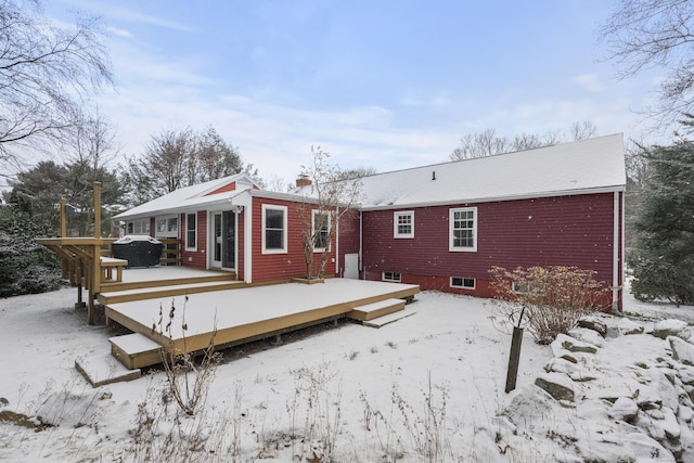 snow covered back of property featuring a wooden deck