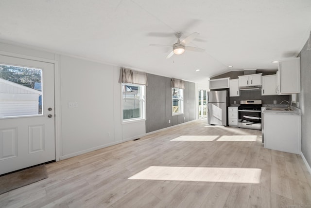 kitchen featuring white cabinets, stainless steel appliances, a healthy amount of sunlight, and light hardwood / wood-style floors