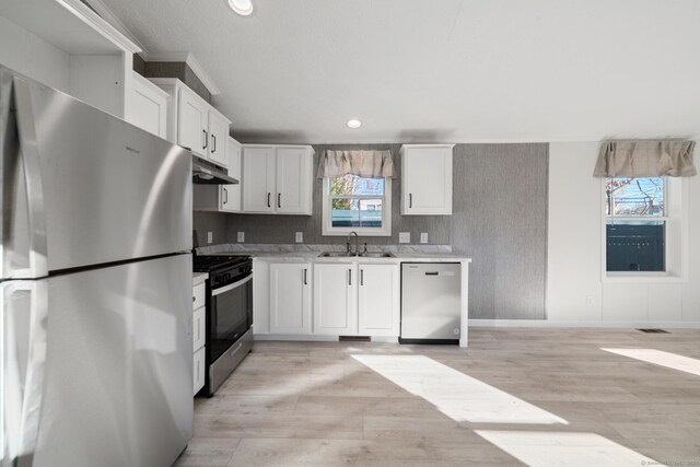 kitchen featuring sink, white cabinets, light hardwood / wood-style floors, and appliances with stainless steel finishes