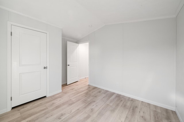 spare room with light hardwood / wood-style flooring, lofted ceiling, and ornamental molding