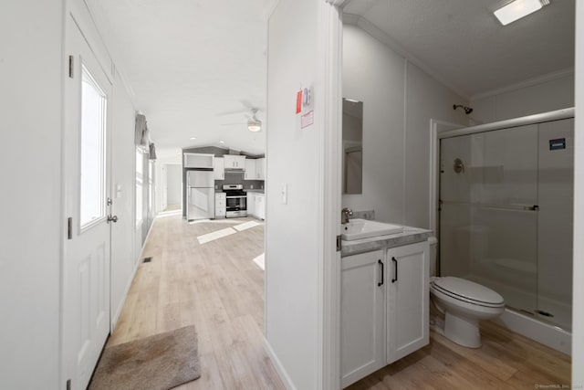 bathroom with hardwood / wood-style flooring, crown molding, a shower with shower door, and lofted ceiling