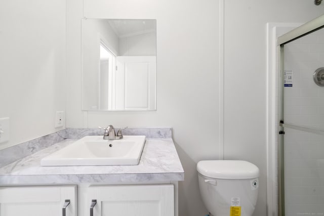 bathroom featuring crown molding, a shower with door, vanity, and toilet