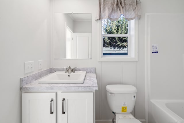 bathroom featuring a bathing tub, vanity, and toilet