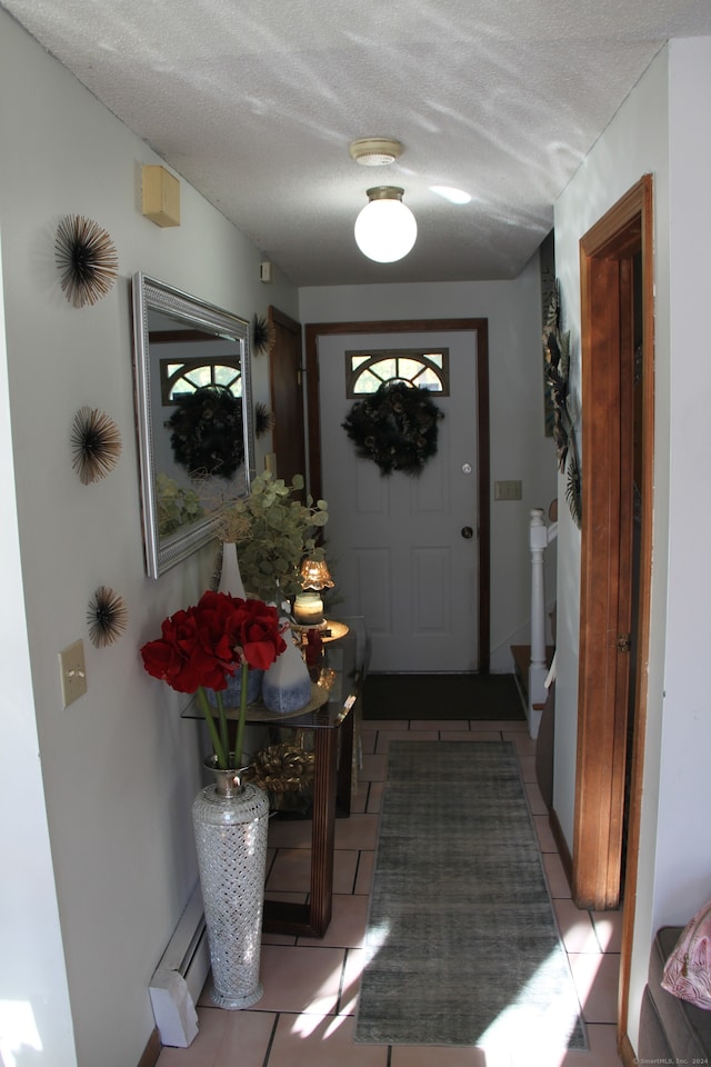 entryway featuring light tile patterned flooring, a textured ceiling, and a wealth of natural light