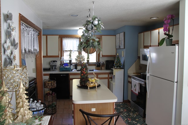 kitchen featuring a textured ceiling, a center island, white appliances, and tile patterned flooring